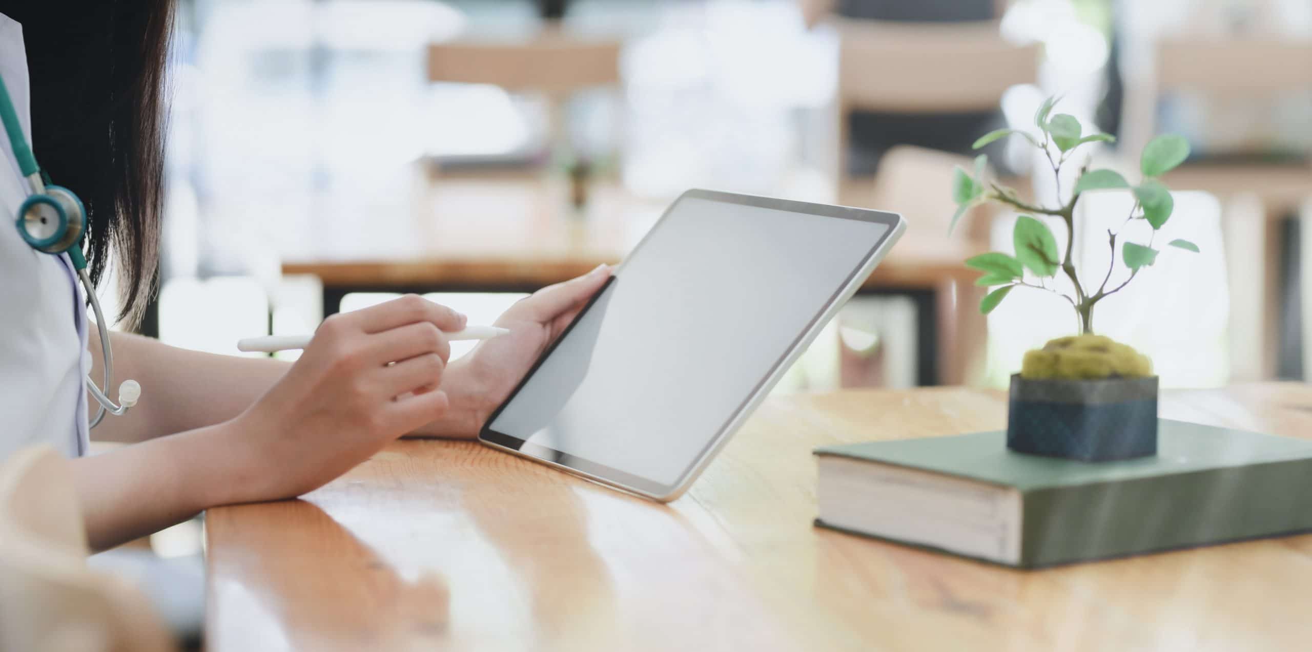 Person Leaning on Wooden table holding tablet considering ageism examples